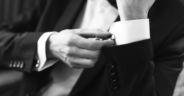 man buttoning his cufflinks