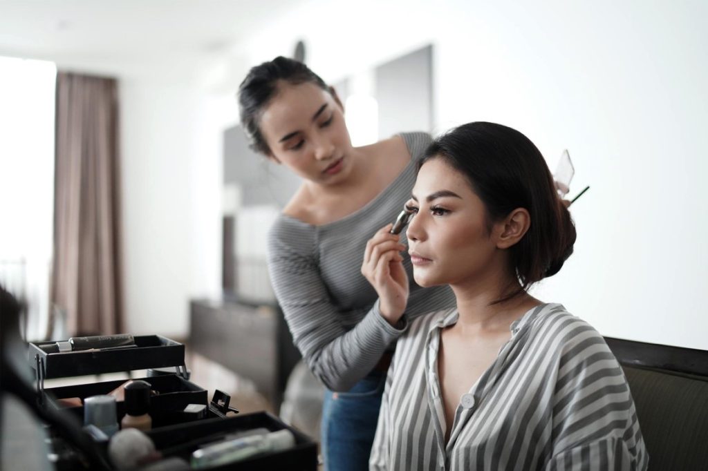 woman doing makeup on friend