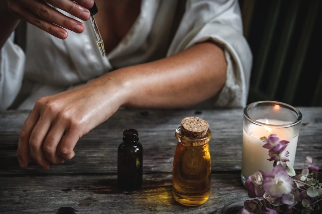 woman dropping an oil on her hand