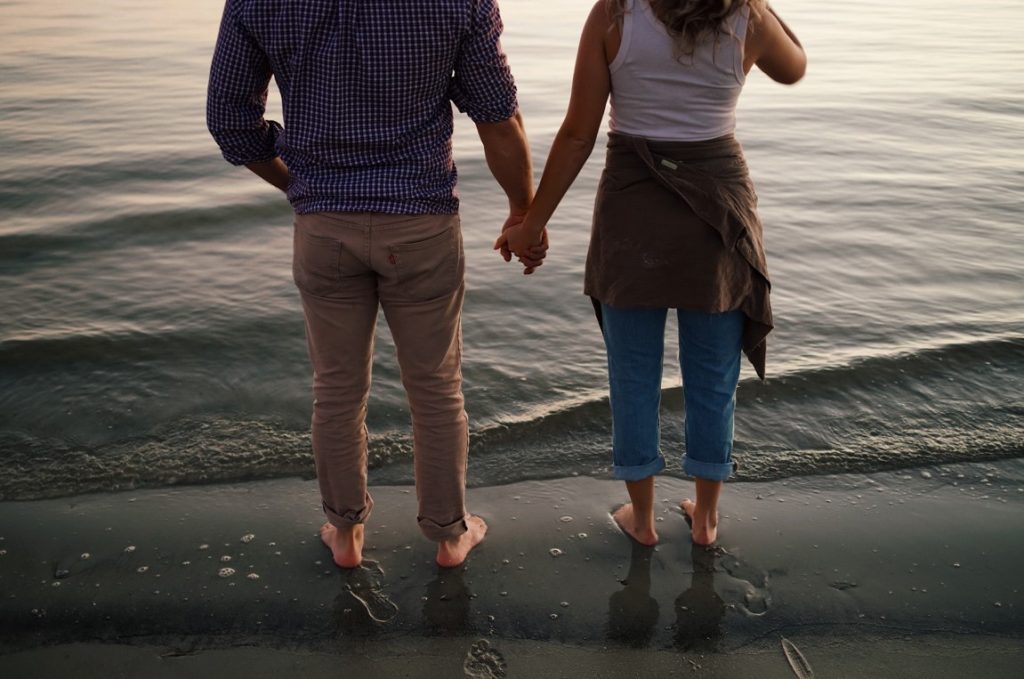 couple holding hands on the beach