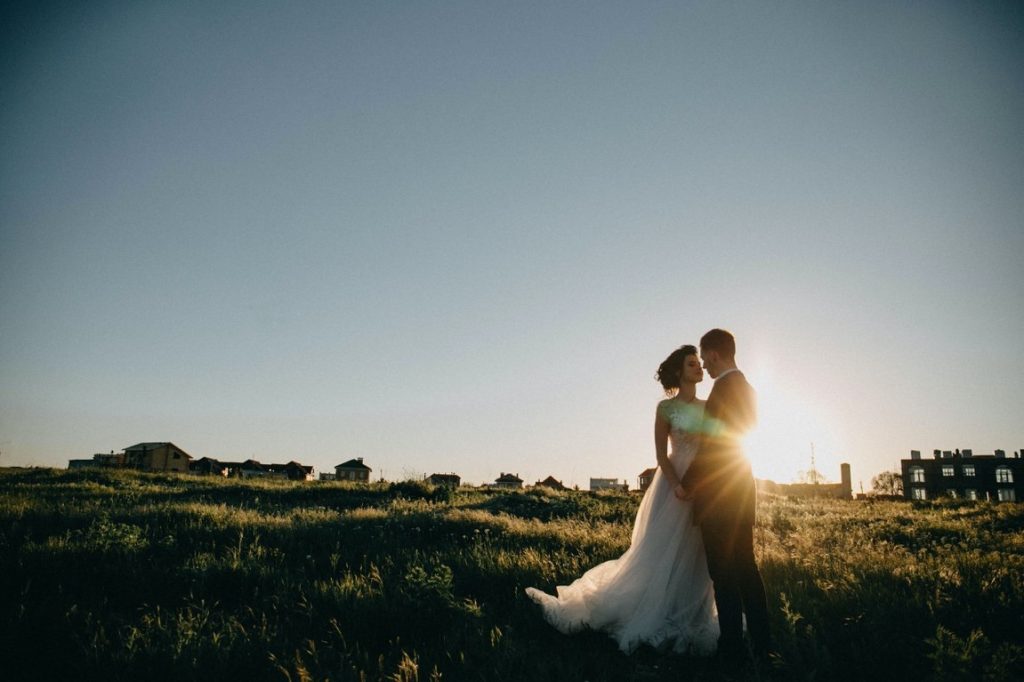 portrait of newlywed on a field during sunset