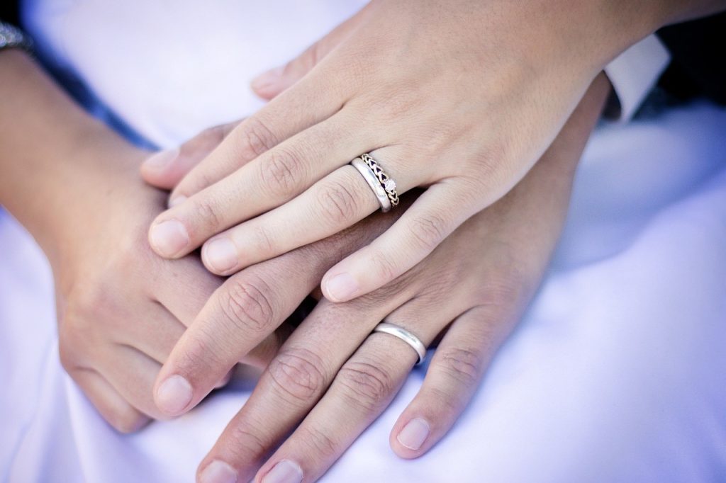 bride and grooms hands with wedding rings