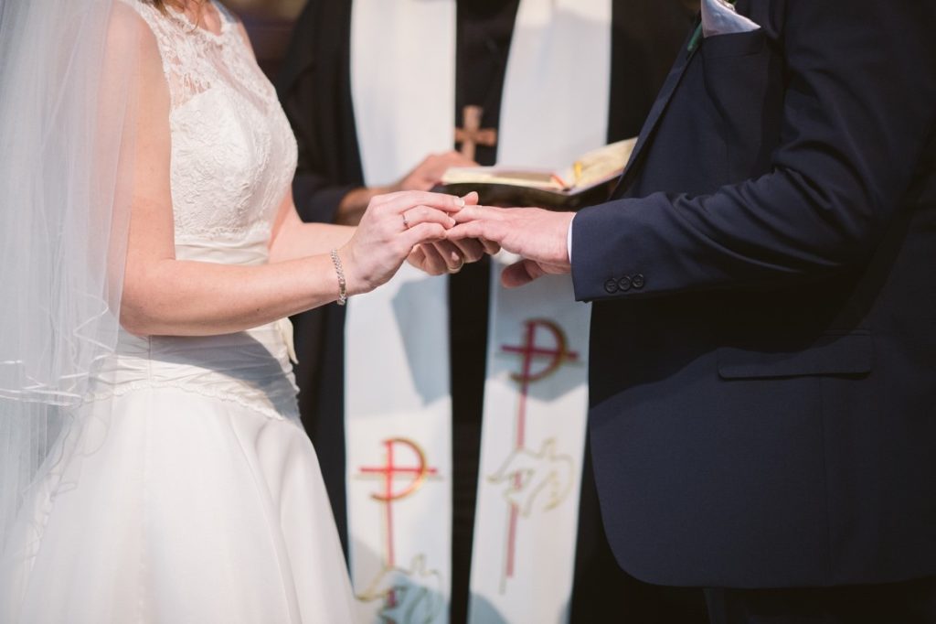 bride putting on ring to the groom