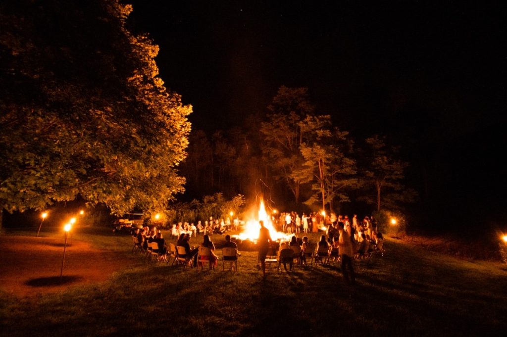 group of people circling around a bonfire
