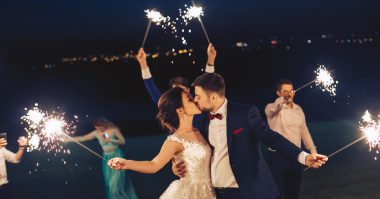 newlyweds and friends playing with fire sparkles