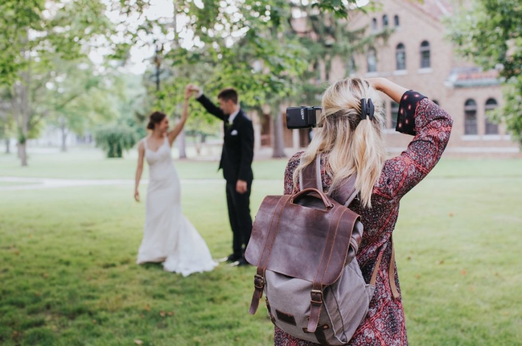 photographer taking picture of newlyweds dancing