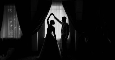 silhoutte of bride and groom dancing by the window