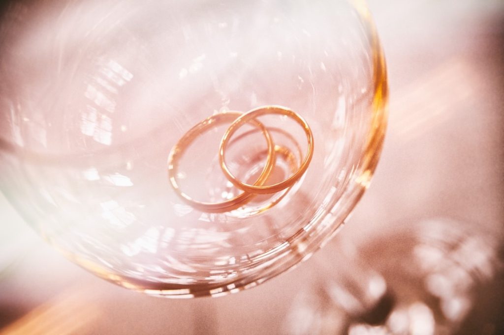 wedding rings on wine glass