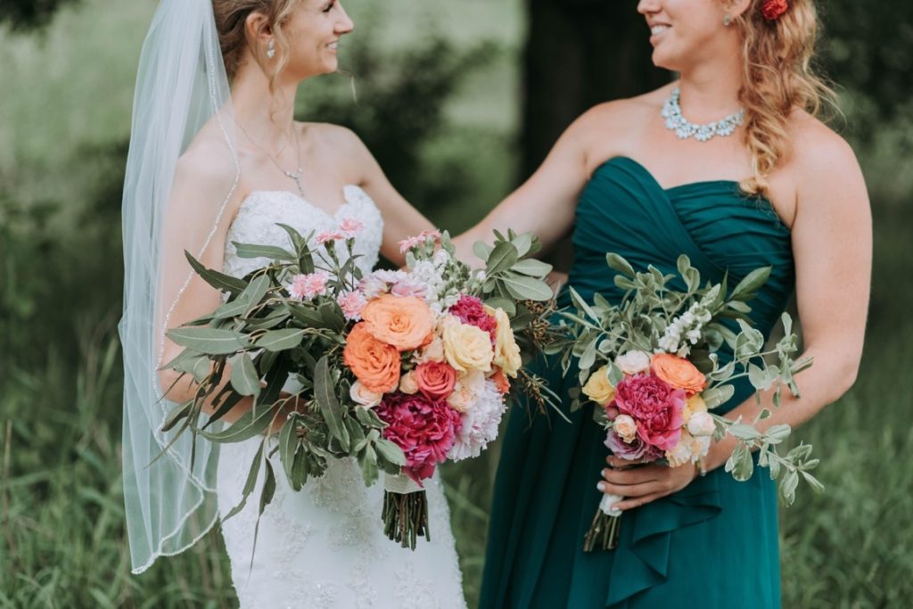 bride and bridesmaid smiling at each other