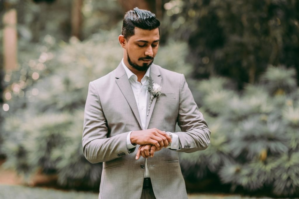 man wearing suit looking at his watch