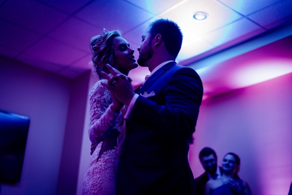 newlyweds dancing under neon lights