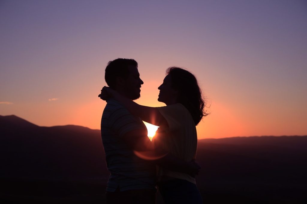 silhoutte of man and woman hugging