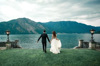 wedding couple running along the grass
