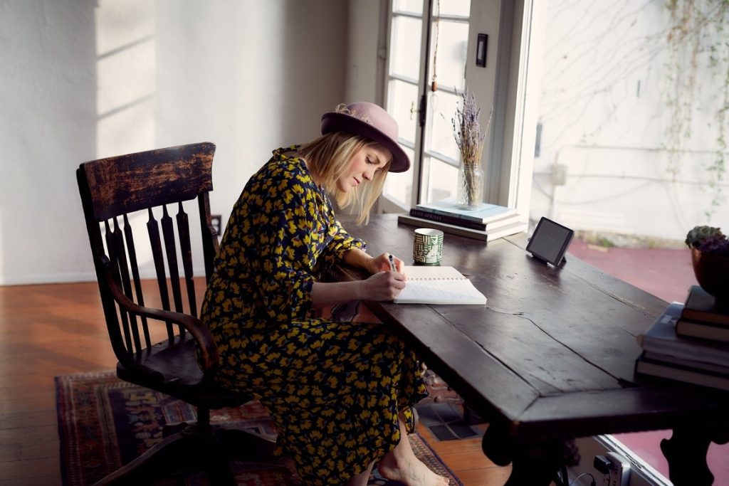 woman writing on a wooden table