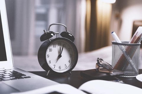 alarm clock beside a laptop