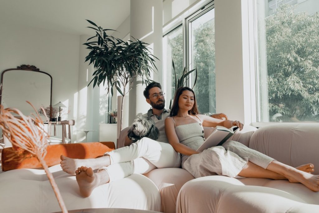 couple sitting on couch with a dog