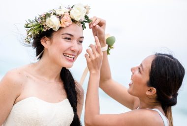 friend fixing flower crown of bride