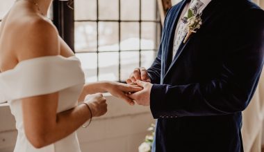 groom putting ring on bride