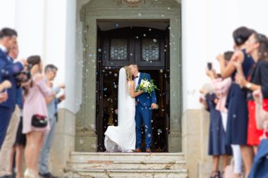 Newlyweds kissing while exiting the church