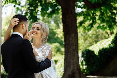 newlyweds standing under a tree