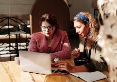 two woman sitting by the table