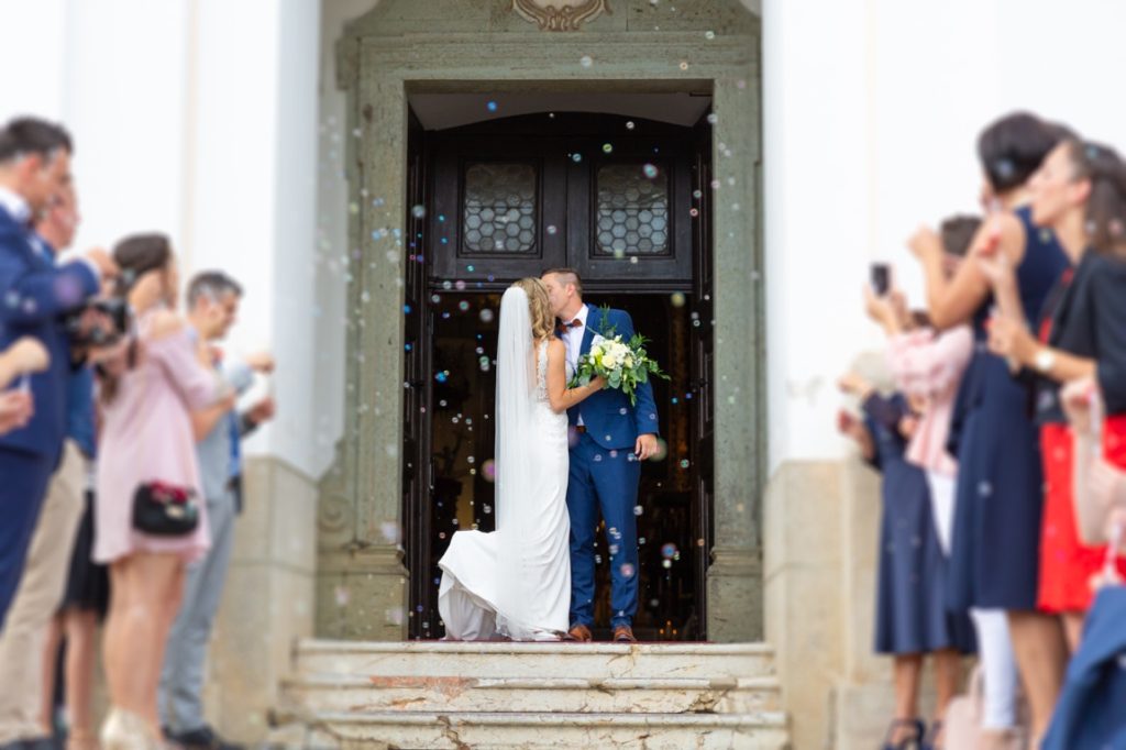 bride and groom kissing outside church