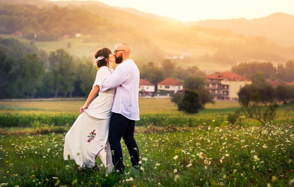 man and woman kissing on a field