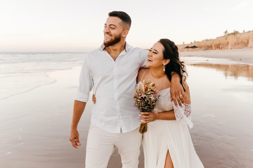 newlyweds laughing on the shore