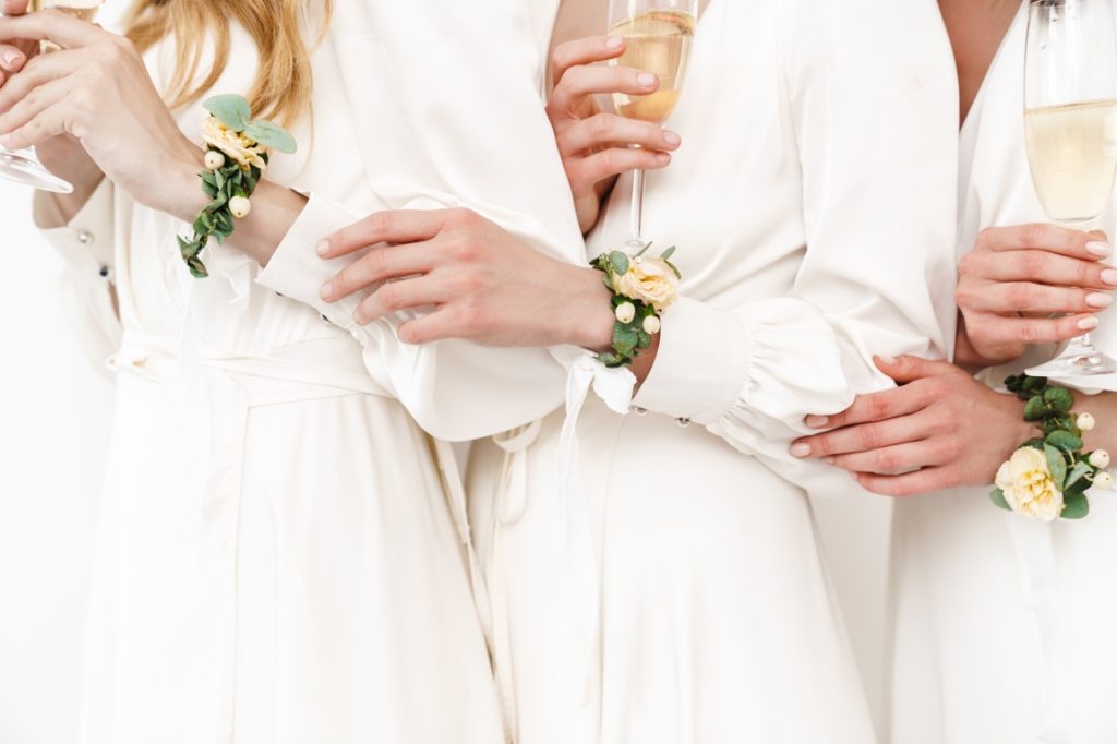 women wearing robe and holding wine