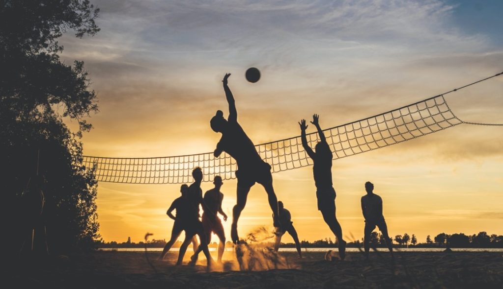 friends playing volleyball on the beach