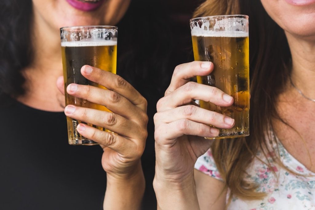 two woman holding beer