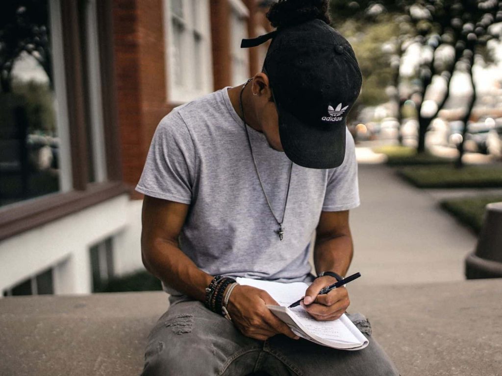 man writing on a notebook