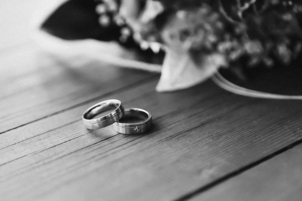 monochrome photo of wedding rings