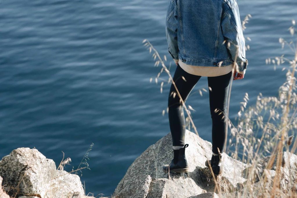 woman standing on a boulder