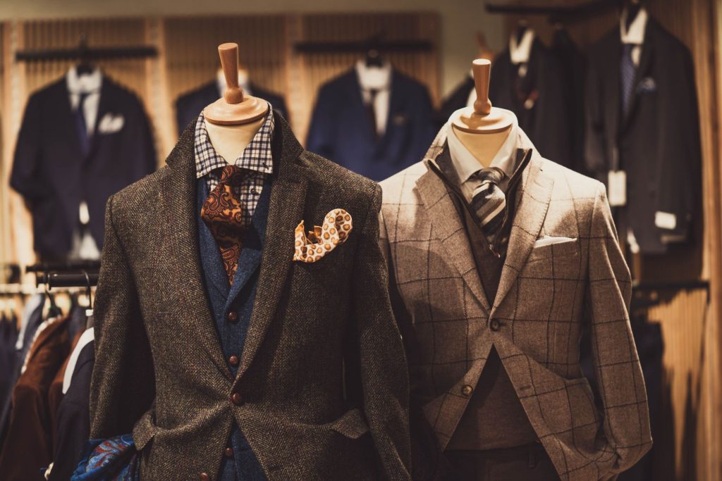 a clothing store with blazers and ensembles on mannequins