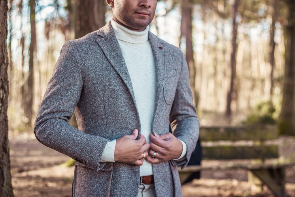 man wearing white turtleneck under a gray coat