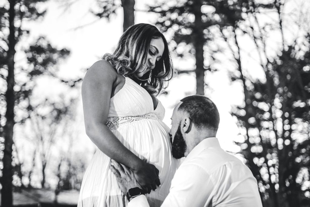 a man kissing the baby bump of his partner