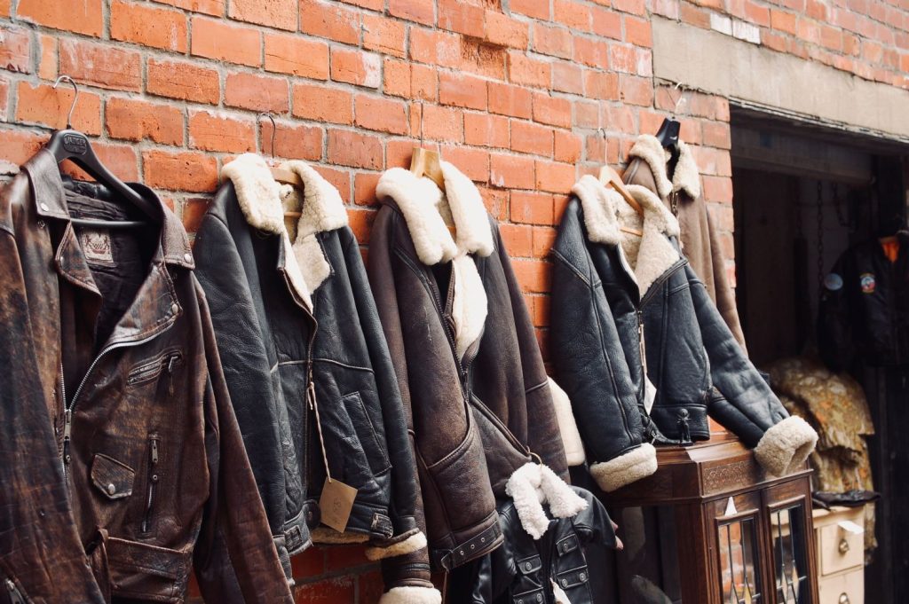 different styles of leather jackets displayed along a wall