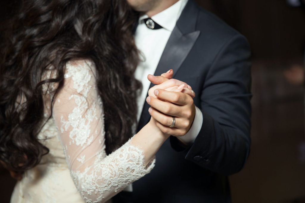 newly married couple holding hands while dancing