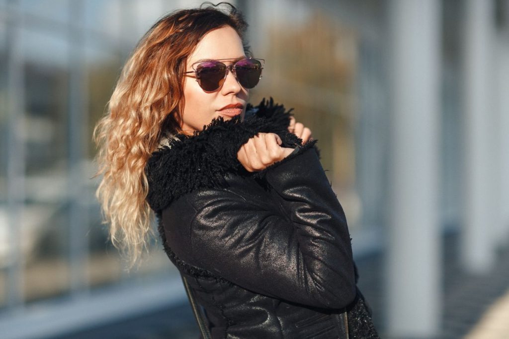 woman wearing sunglasses and a black leather jacket with fur