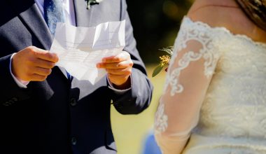 groom holding a piece of paper while exchanging vows with bride