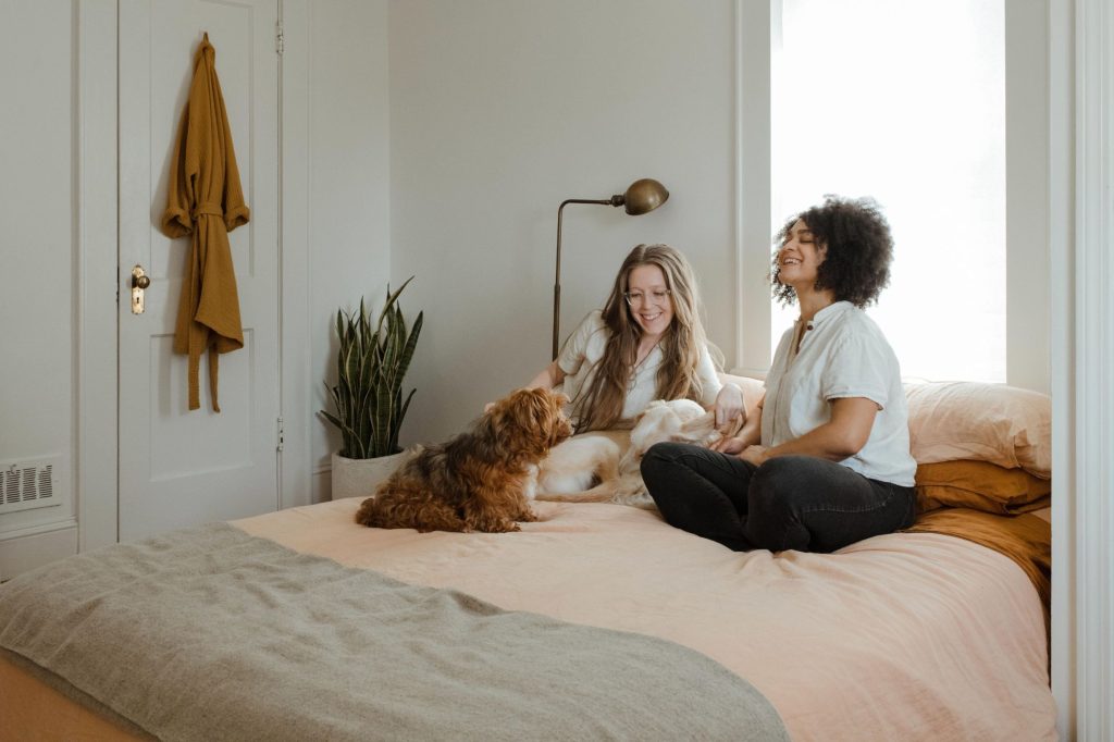 lesbian couple sitting in bed with their pets