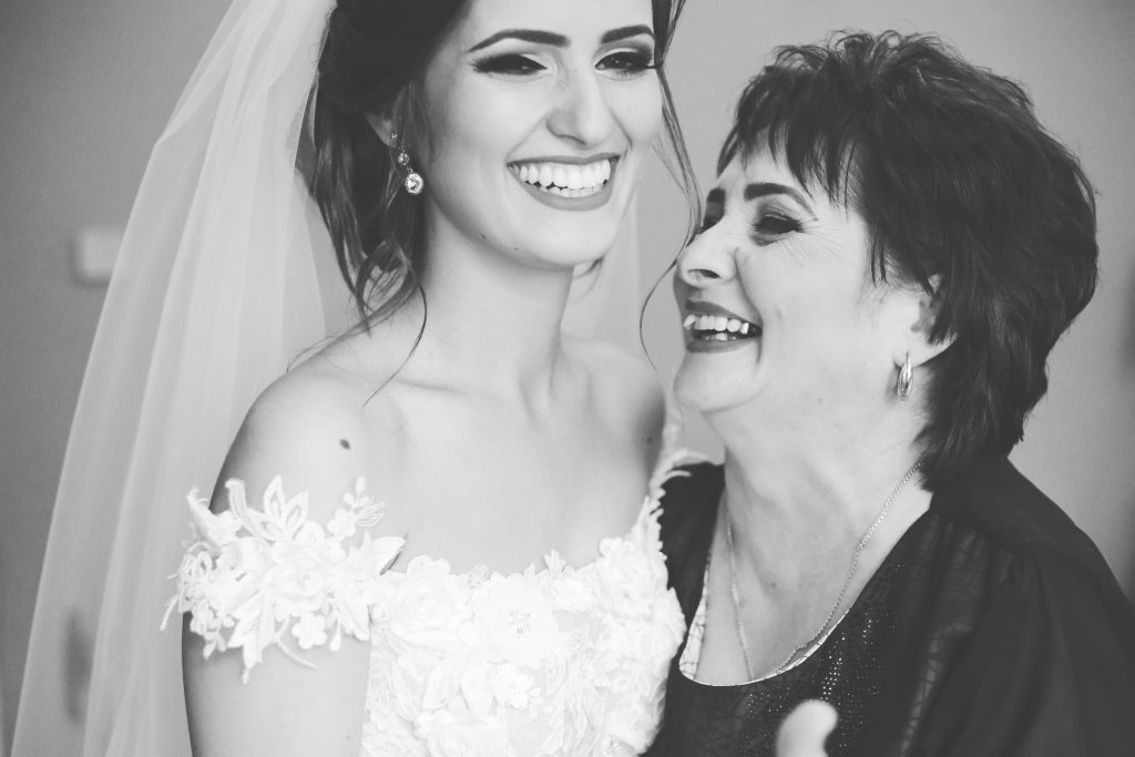 mother in law embracing bride wearing wedding dress