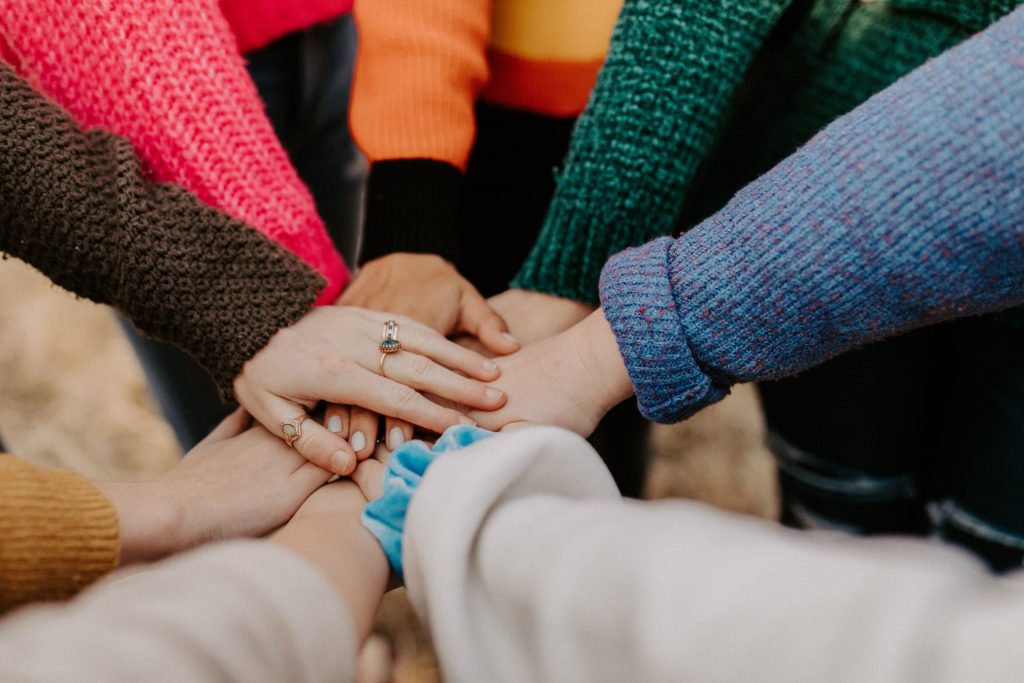 several people piling their hands together