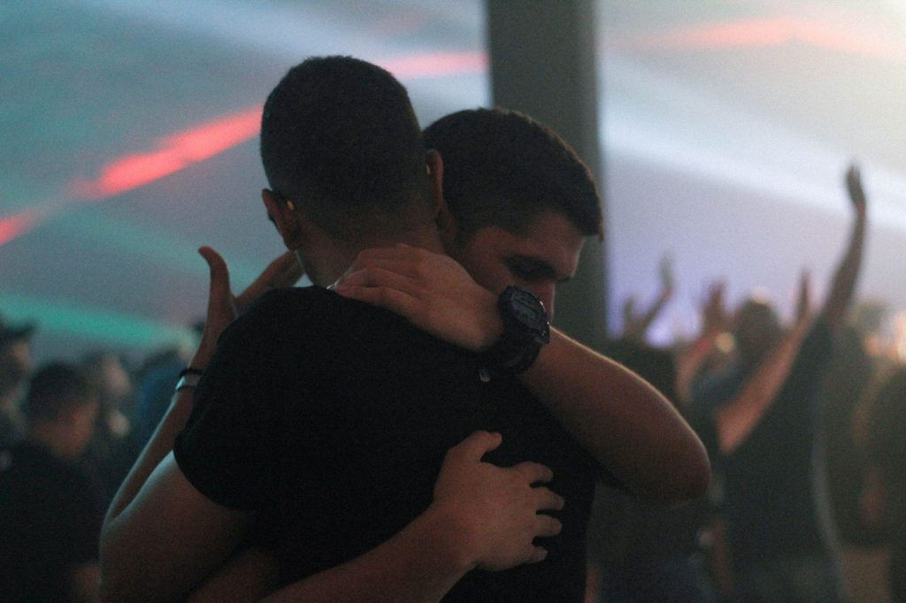 two men hugging emotionally during church