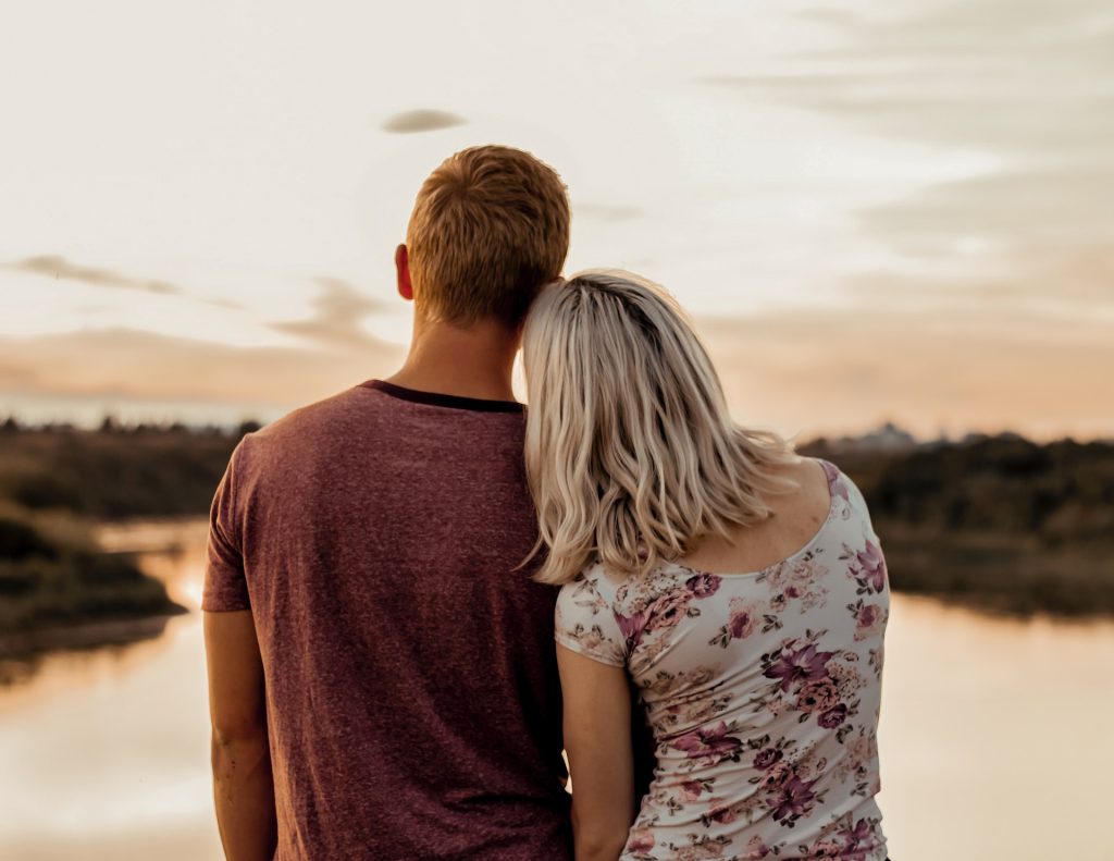 couple leaning into each other as they look out into a lake