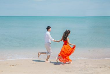 man and woman walking on the shore